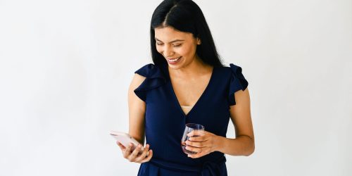 smiling business owner sending personalized text messages to customer from her phone