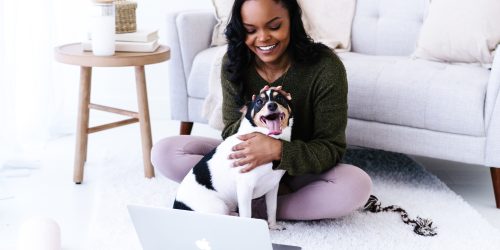 coach cuddling dog on camera during livestream with her online coaching group